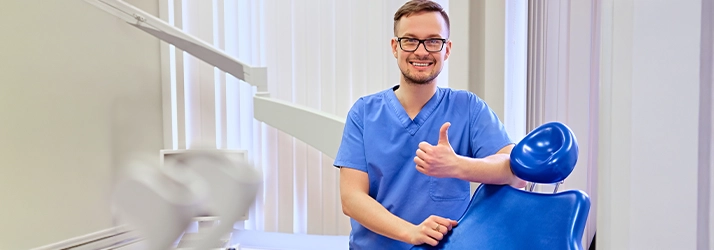 Man Giving Thumbs Up Next To Dental Chair